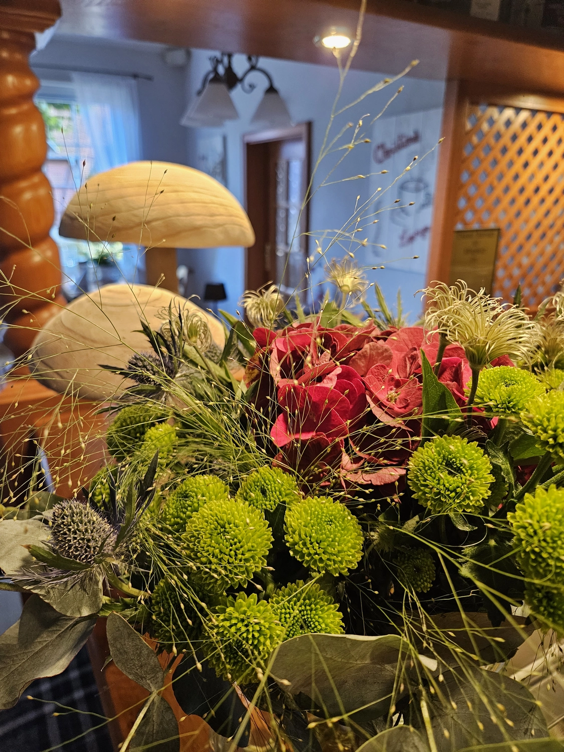 Wegeners Landhaus UG – Hotel & Restaurant – Ein farbenfroher Blumenstrauß mit roten Hortensien und leuchtend grünen Chrysanthemen.